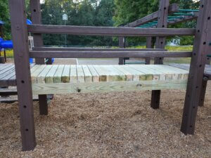 Playground bridge that has been repaired with new wood