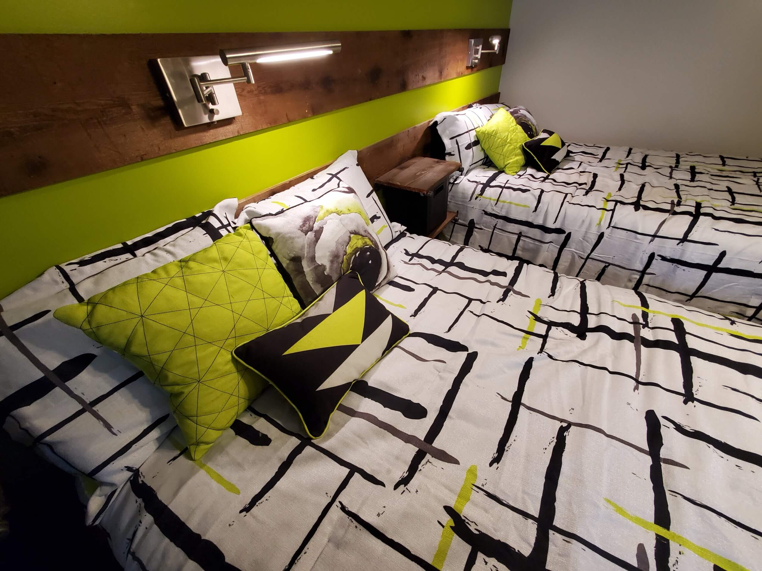 Bed with lamp overhead and decorative pillows on the comforter
