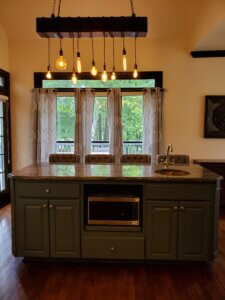 Industrial statement light with vintage bulbs hanging over traditional kitchen island